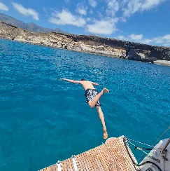 Guest photo: dive in Guest diving off the yacht into clear blue water, south Tenerife coast behind