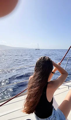 Guest photo: looking for fins Guest with long hair looking out to sea from the side of the yacht
