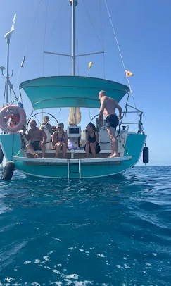 Swim ladder down at the anchorage Guests relaxing on the stern of a sailing yacht with the swim ladder down